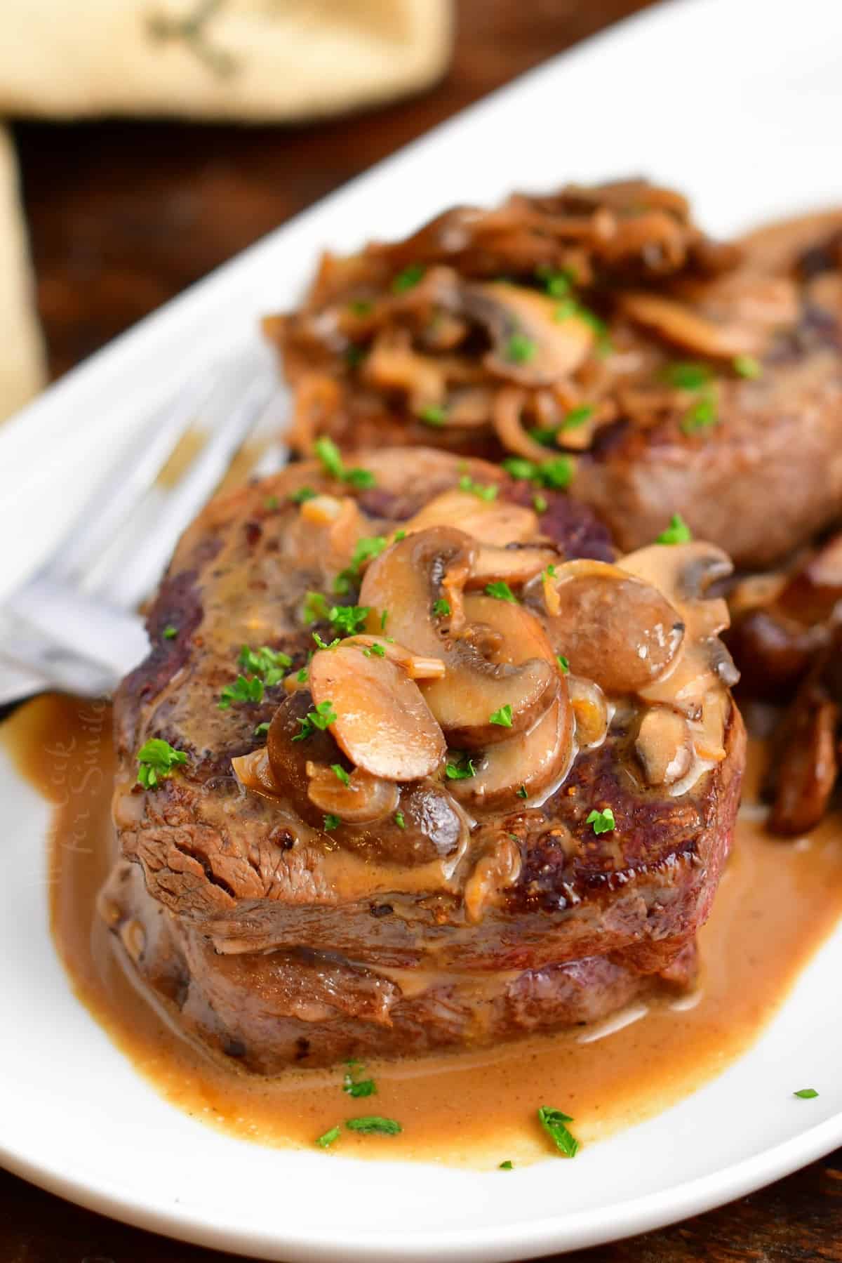 closeup: Steak Diane on a white platter with a fork