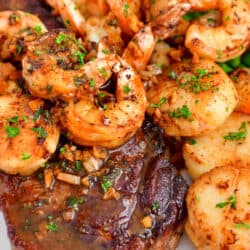 cooked steak and shrimp on plate with asparagus
