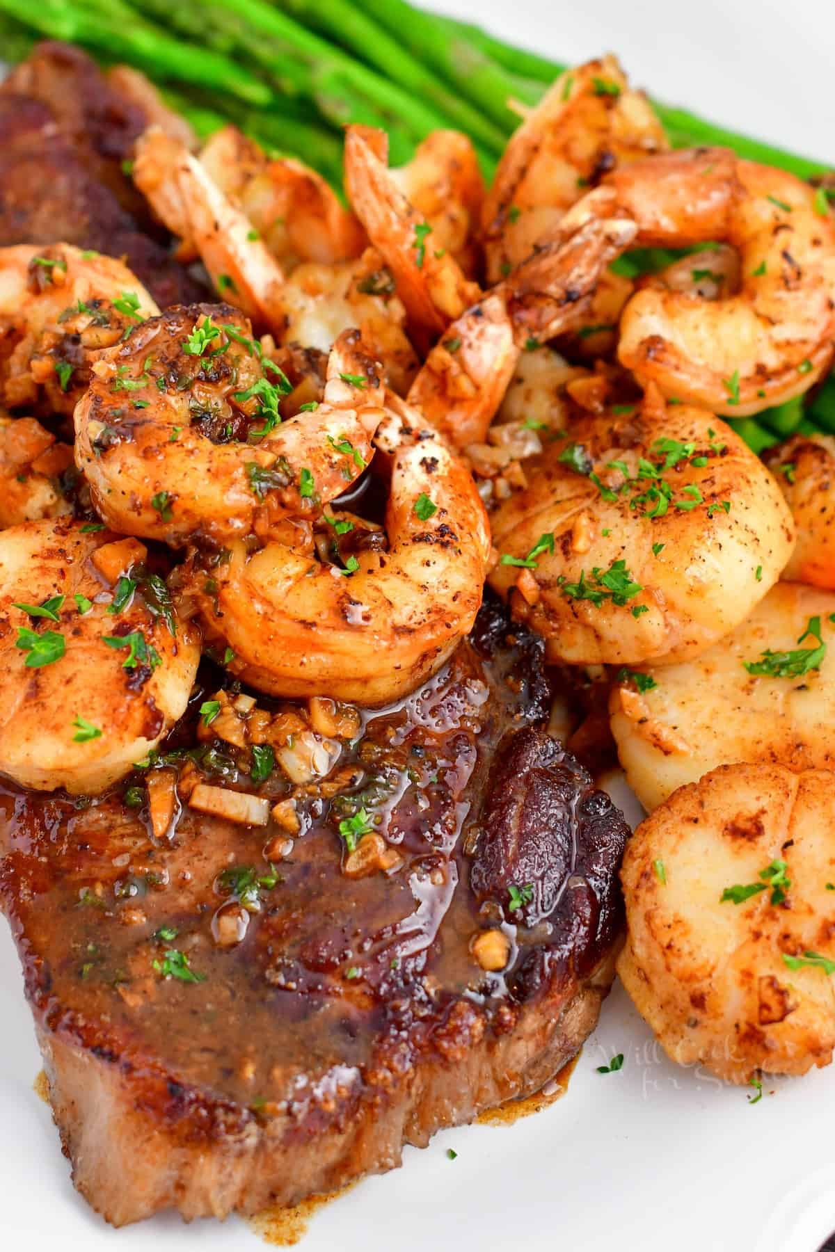 cooked steak and shrimp on plate with asparagus