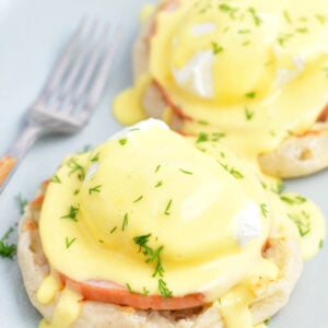 Two servings of Eggs Benedict are on a white plate.