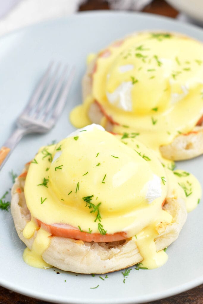 Two servings of Eggs Benedict are on a white plate.
