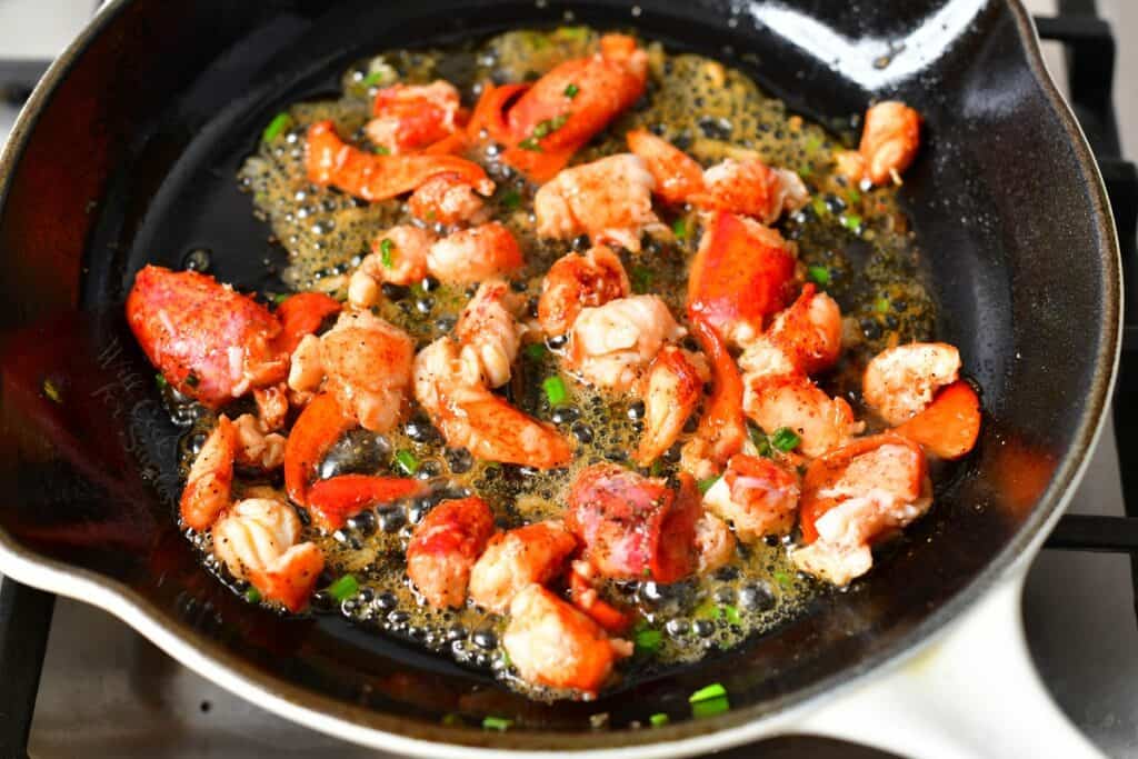 chunks of lobster cooking in garlic butter
