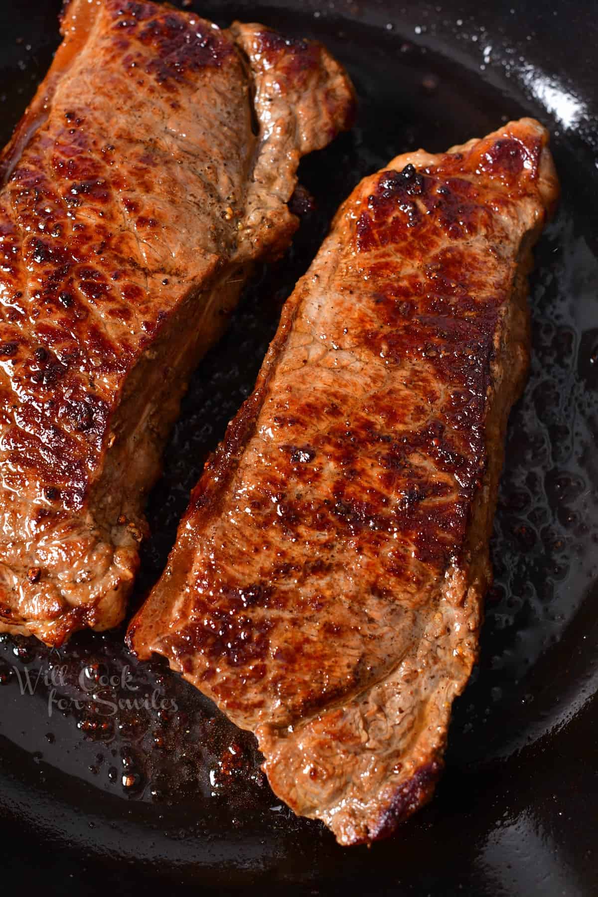 overhead: two new york strips with a brown crust
