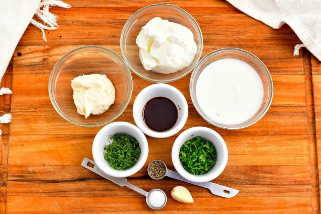 buttermilk ranch dressing ingredients on a wooden cutting board