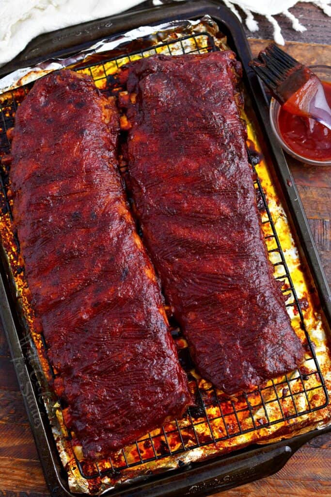 two racks of oven baked ribs brushed with sauce