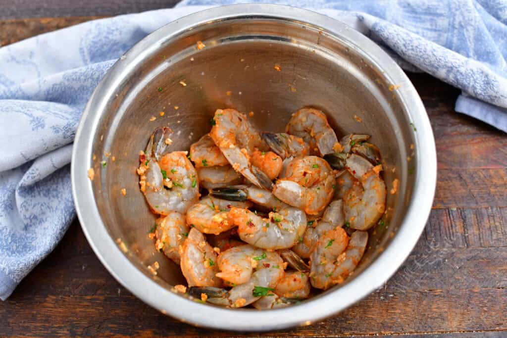 tossing raw shrimp with seasoning in mixing bowl for an easy shrimp recipe