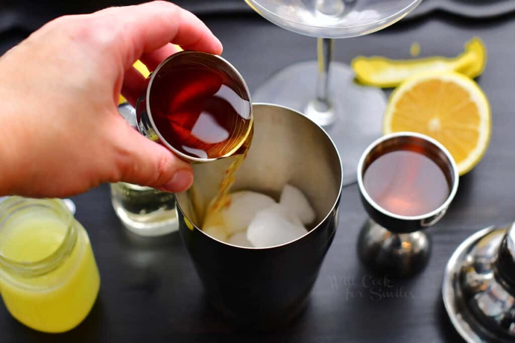 pouring in cognac into the cocktail shaker with ice