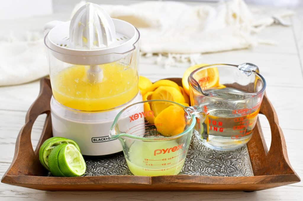 freshly squeezed citrus juice and a measuring cup of simple syrup