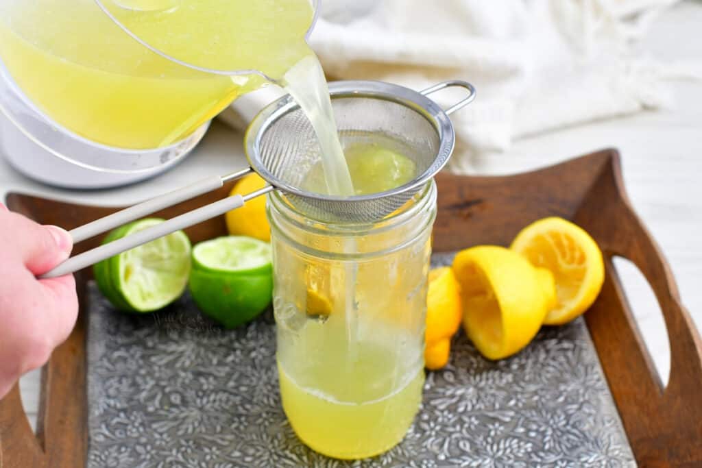 straining liquid into a jar for cocktail mixers