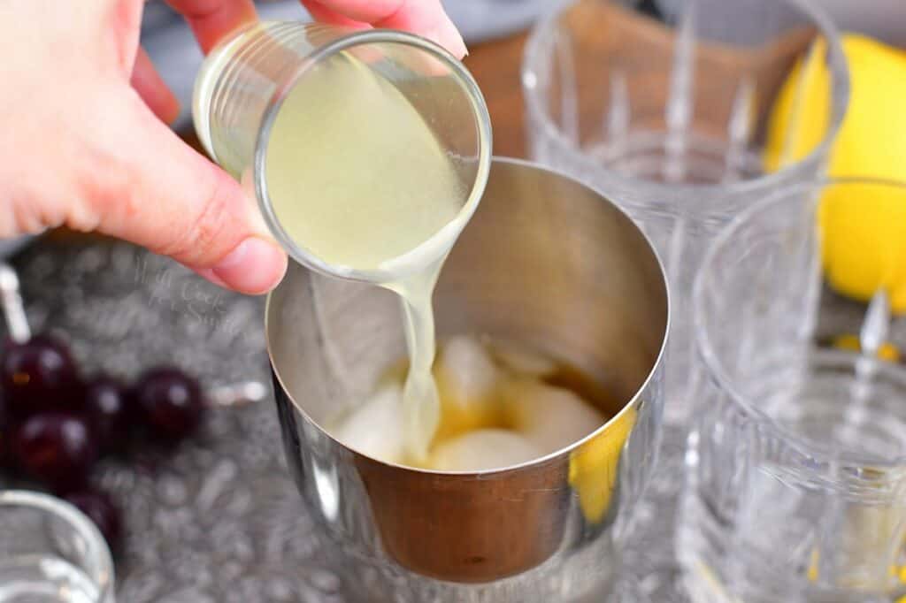 Lemon juice is being added to the cocktail shaker. 