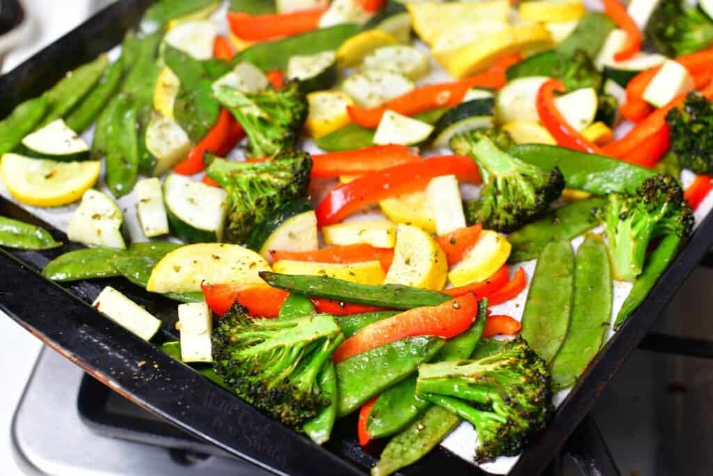Baked vegetables are on a baking sheet.