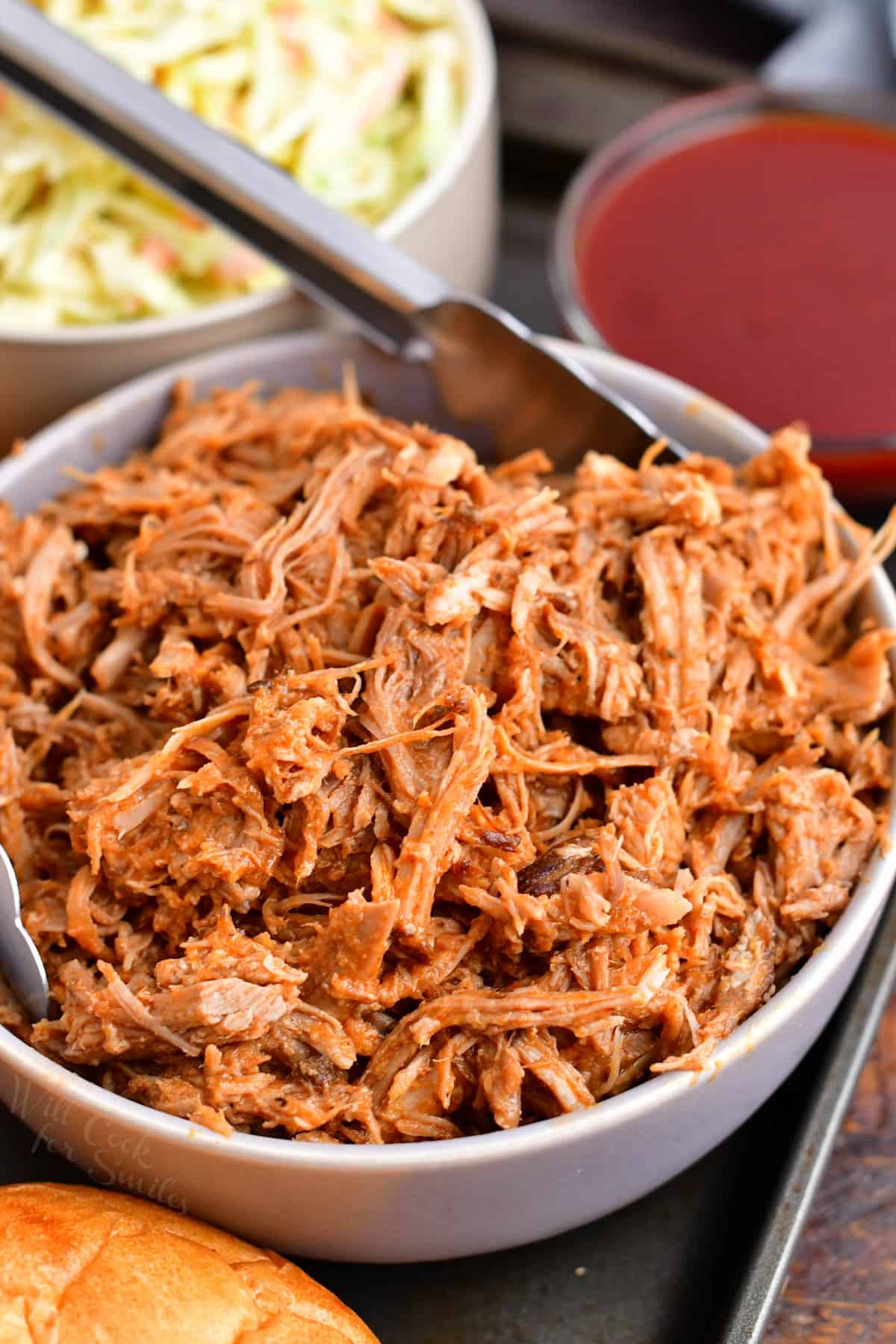 Pulled pork is placed in a white bowl.