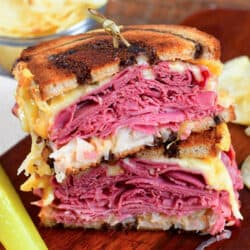 cooked Reuben sandwich halves stacked on top of each other.