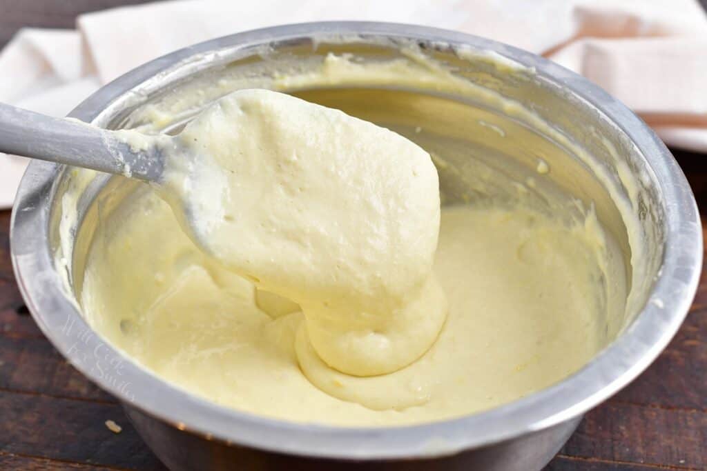 A rubber spatula is mixing pancake batter.