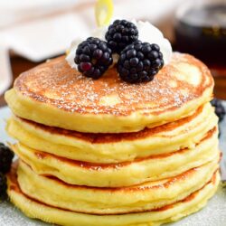 A stack of ricotta pancakes is ready to be eaten.