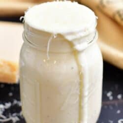 front side view of alfredo sauce in a mason jar.