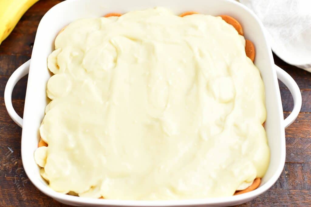 Pudding is spread evenly over the top of banana pudding.