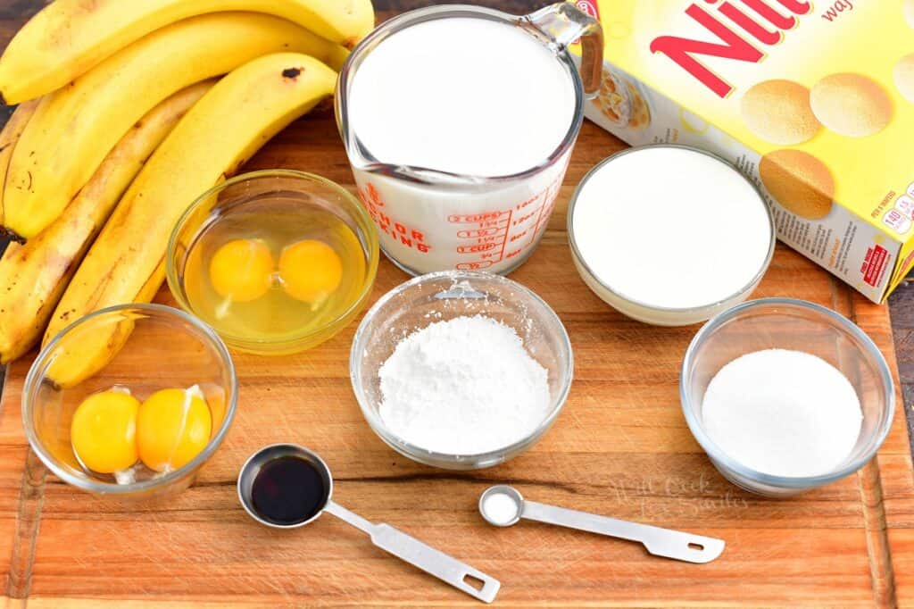 The ingredients for banana pudding are placed on a wooden surface.