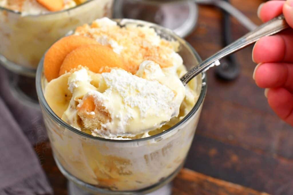 scooping out some banana pudding out of a glass cup