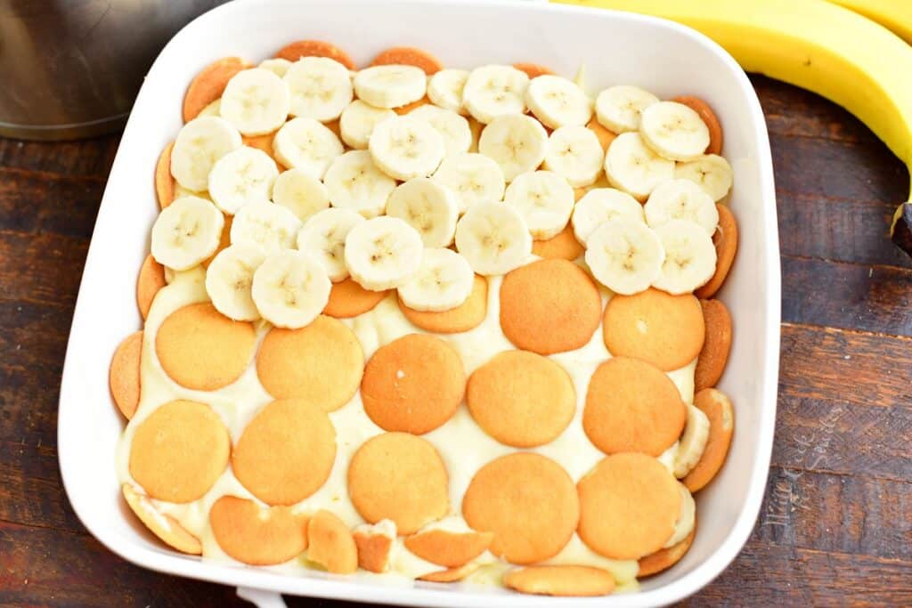 Nilla wafers, bananas and pudding are in a white baking dish.