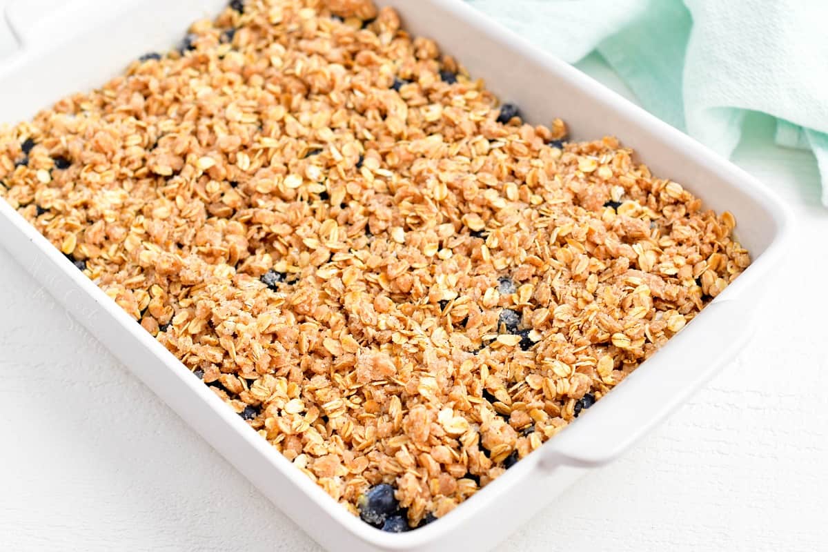 The crisp is spread evenly over the filling in a baking dish. 