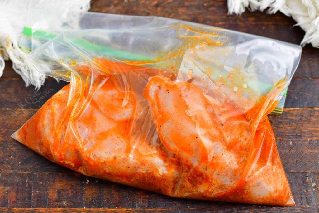 Chicken is marinating in a plastic bag. 