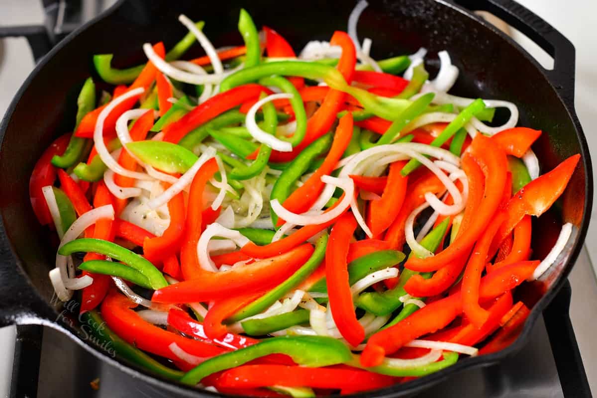 Uncooked veggies are in a large black skillet.