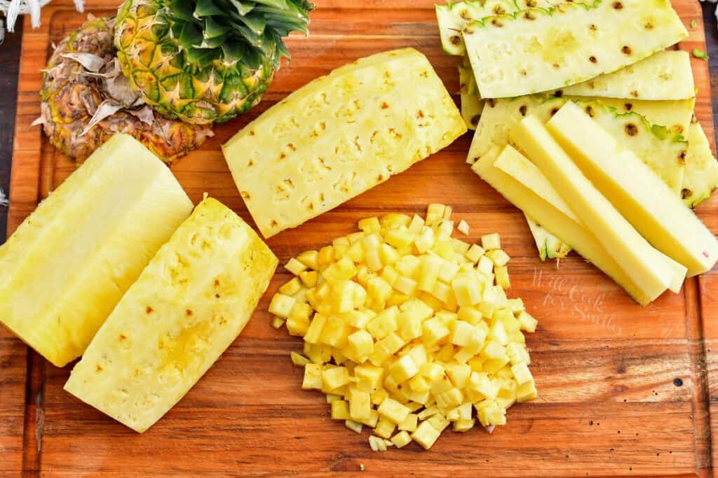 The ingredients for pineapple salsa are placed on a wooden cutting board. 