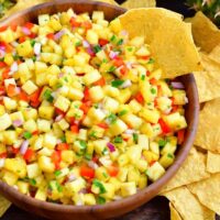 Chips are served alongside pineapple salsa.