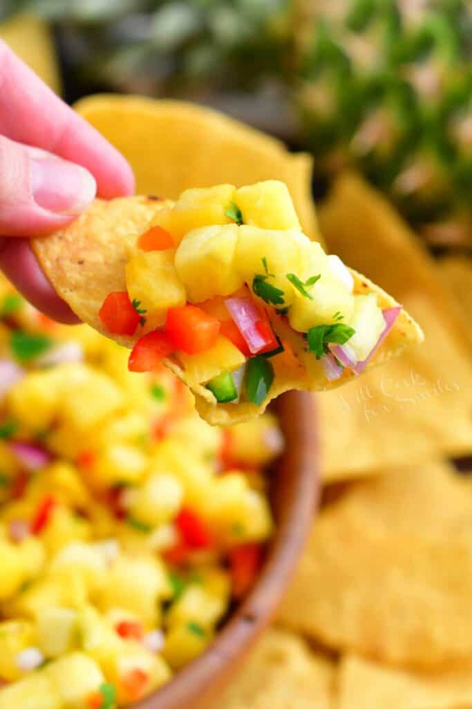 A tortilla chip is topped with salsa.