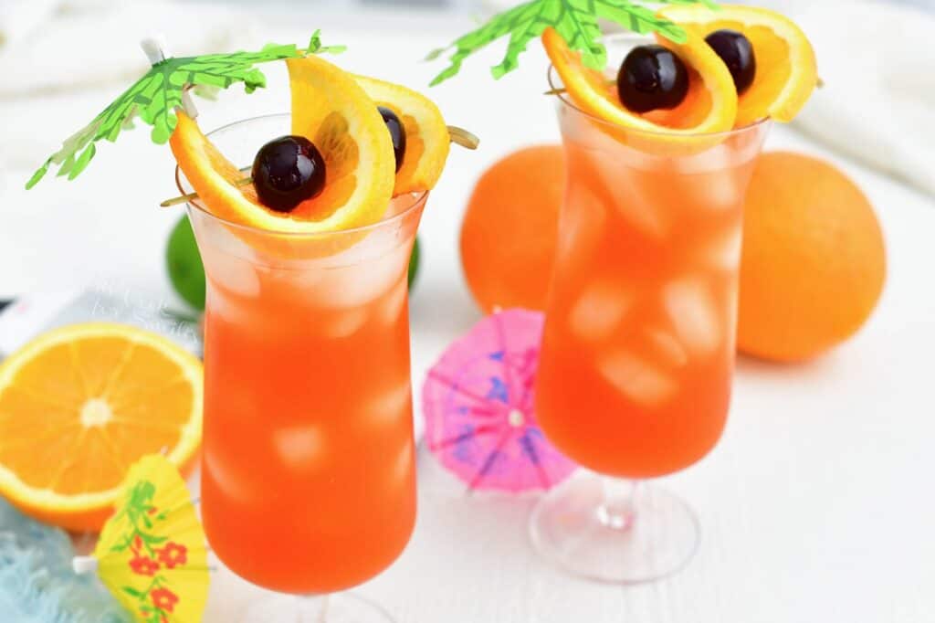 Two glasses of rum punch are set side by side. 