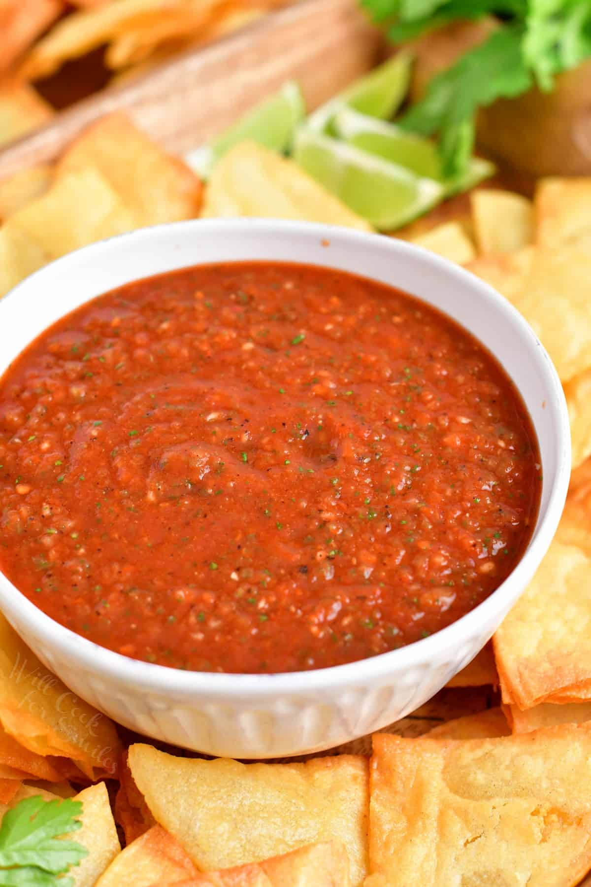 A small white bowl is filled with homemade red salsa.