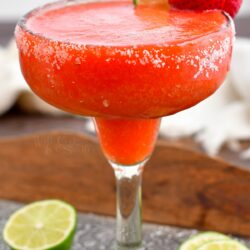 A full glass of chilled strawberry margarita is ready to be enjoyed.