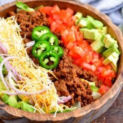 All of the ingredients for taco salad are lined up in a bowl.