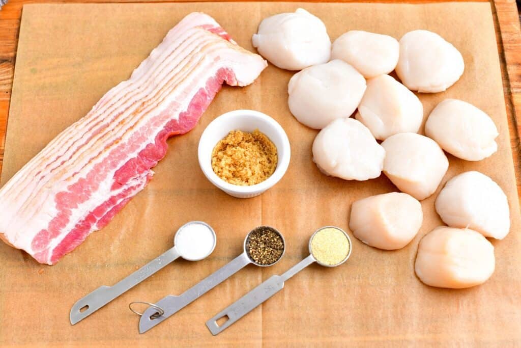 The ingredients for bacon wrapped scallops are placed on a wooden surface.