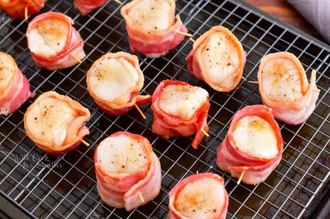 Half baked bacon is wrapped around individual scallops.