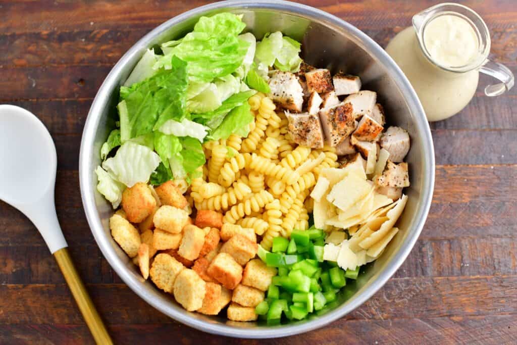 All of the ingredients for the pasta salad are in a large bowl. 