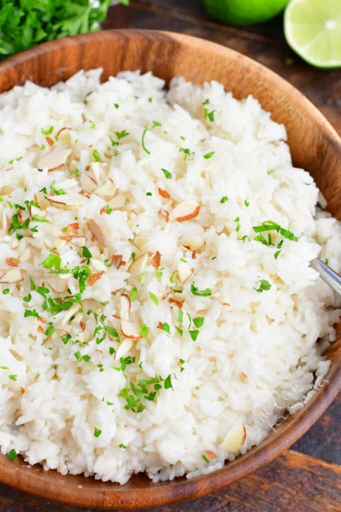 Coconut rice is fluffed and presented in a large serving bowl. 