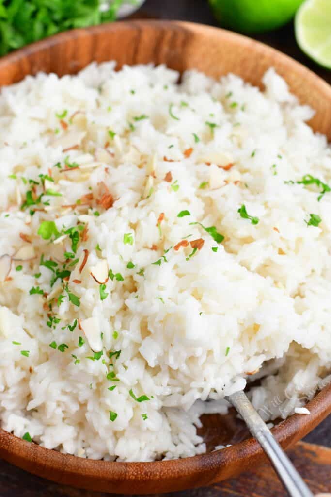 A large wooden bowl is filled with coconut rice.