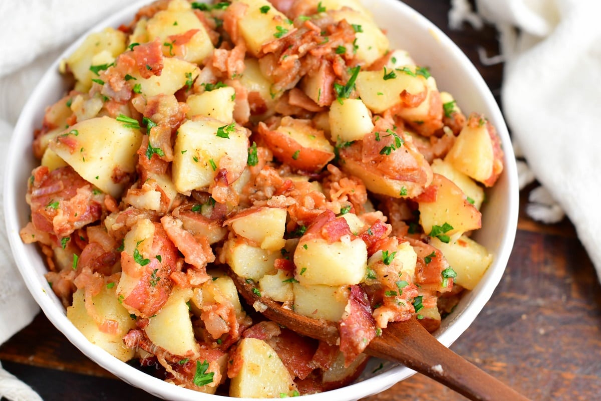 Potato salad is in a large white mixing bowl. 