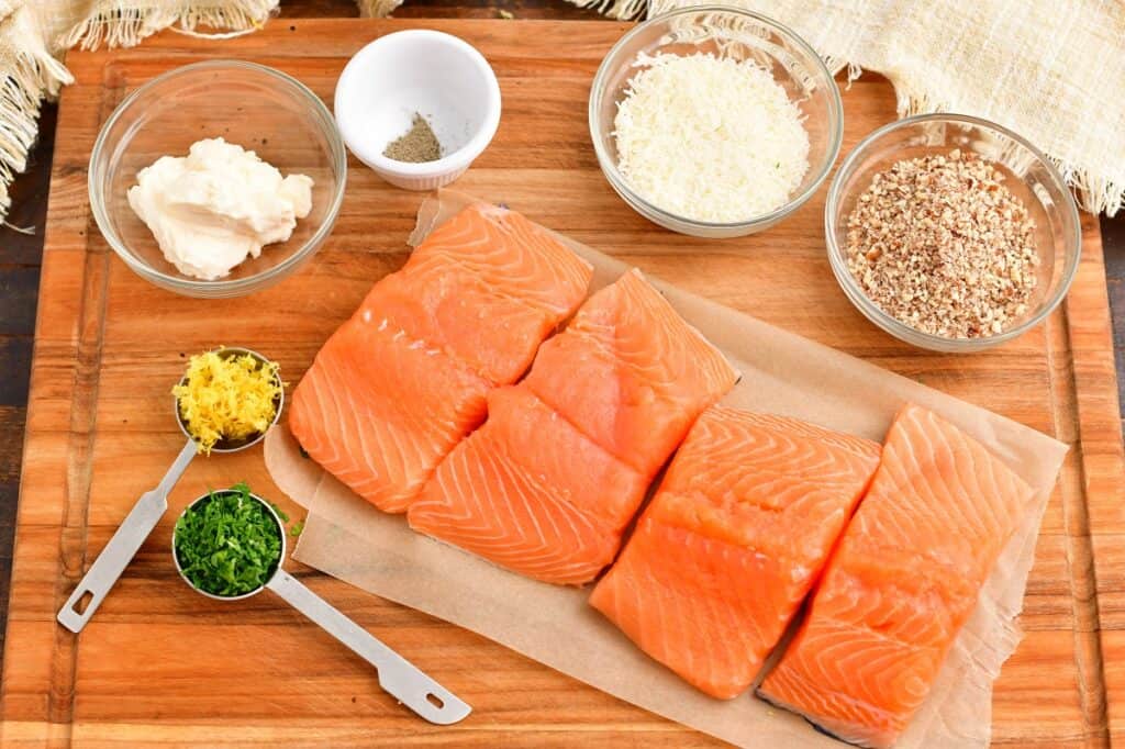 The ingredients for pecan crusted salmon are placed on a wooden cutting board. 