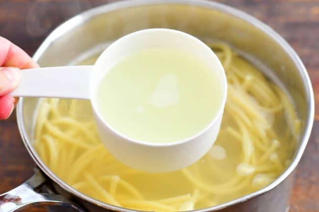 Pasta water is being removed from the pot.