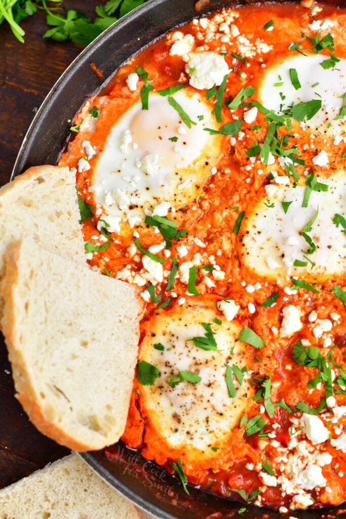 Bread is placed on the side of Shakshuka. 
