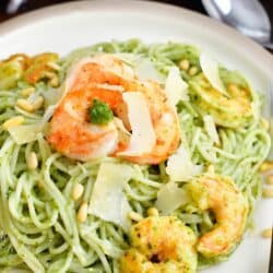 Shrimp and cheese garnish a large potion of pesto pasta.