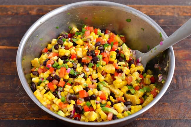 Black bean and corn salad has been tossed in a large bowl. 