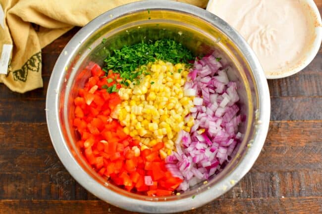 A bowl of un mixed ingredients sits on a wooden surface. 