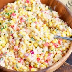 A serving spoon has been placed in the creamy corn salad.