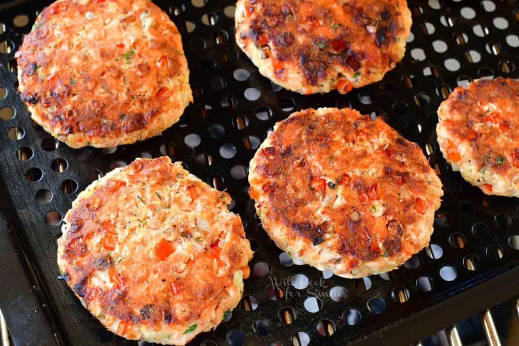 Cooked patties are on a grill.