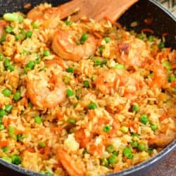 Shrimp fried rice is fully cooked in a black pan.