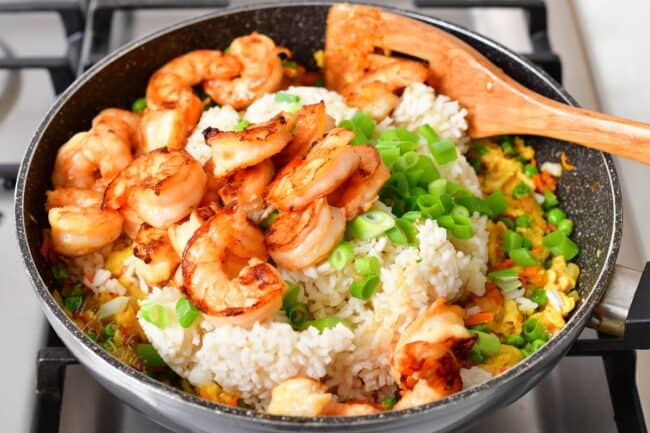 Shrimp and rice have been added to the pan.